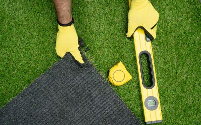 Man's hands with the artificial grass roll and tools